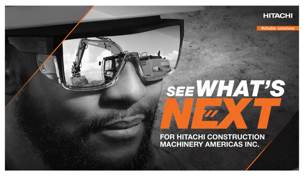 Man with sunglasses that are reflecting a Hitachi excavator on a Hitachi branded graphic that says See What's Next 